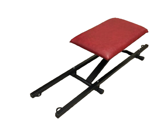 A black metal foldingspanking bench with a red padded seat on top, shown on a plain white background.