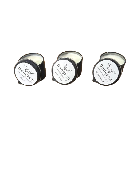 Three small round black candle tins with white labels arranged on a plain white background.