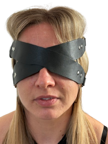 Person wearing a black leather blindfold with metal studs on a white background